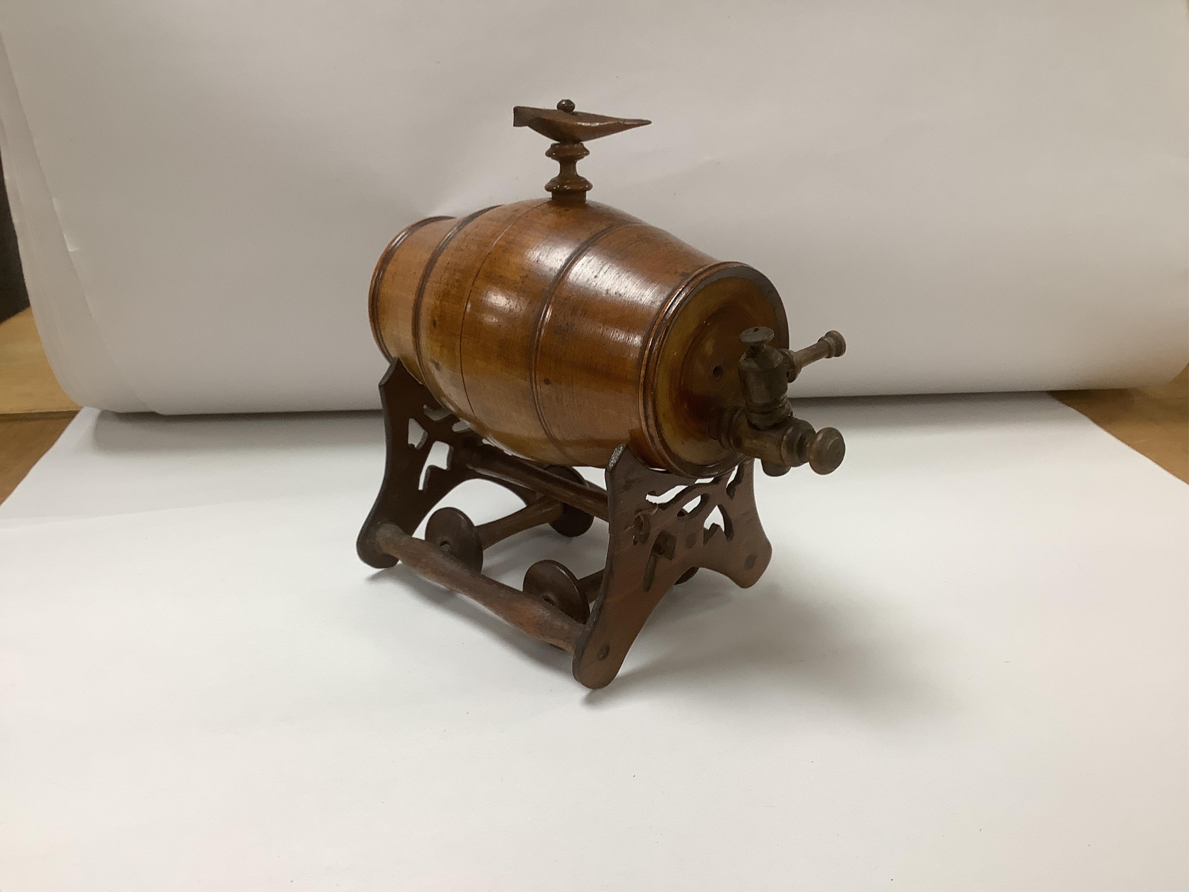 A group of treen to include a spirit barrel with turned wood spigot tap, on wheeled trolley, 17cm long, a pepper grinder, sand timer, etc. (6). Condition - fair